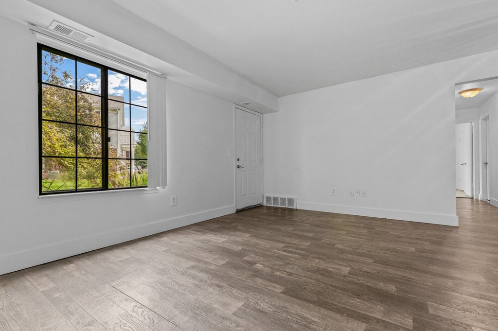 a bedroom with hardwood floors and a large window