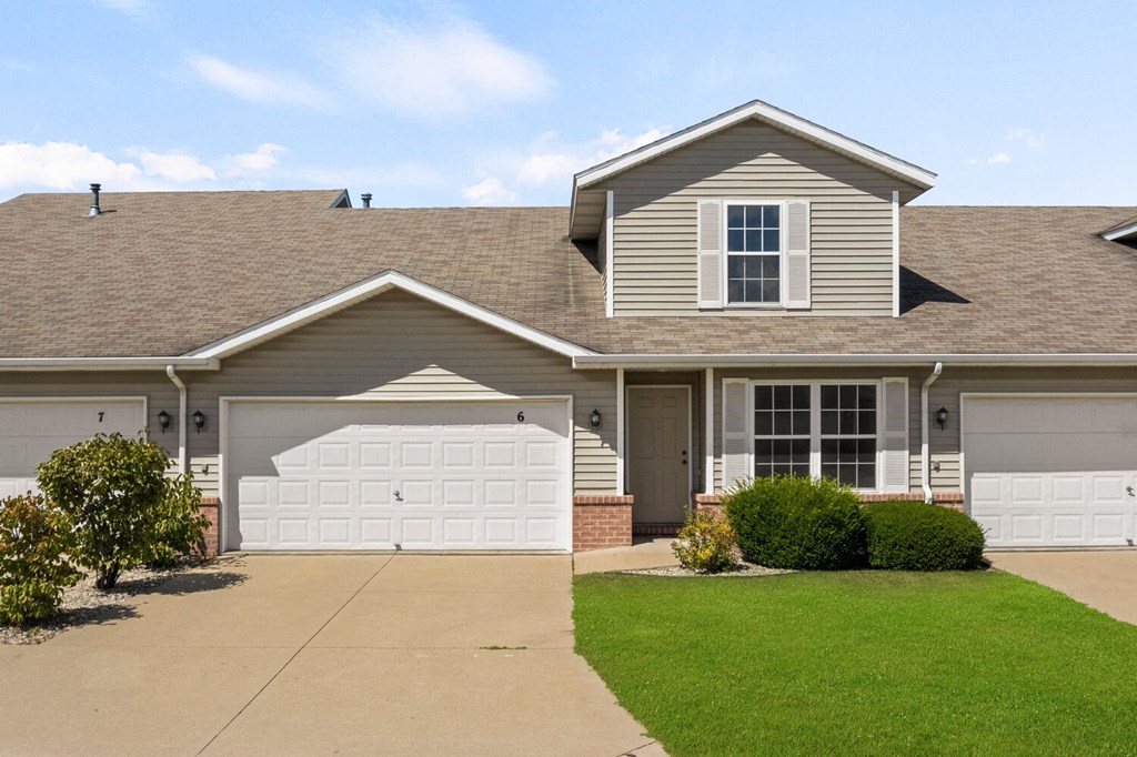 a house with a garage door and a lawn