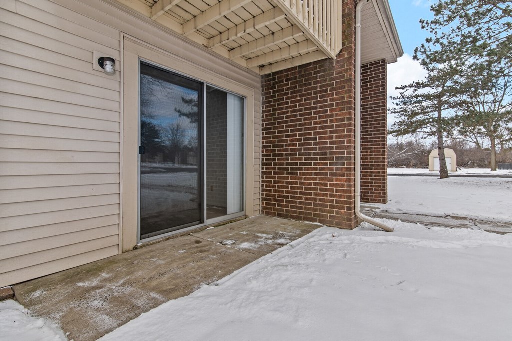 the front door of a brick building with snow on the ground
