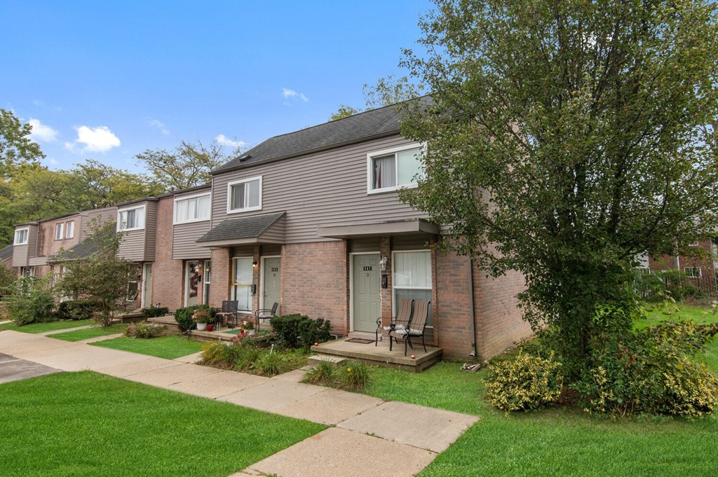 a brick house with a sidewalk in front of it