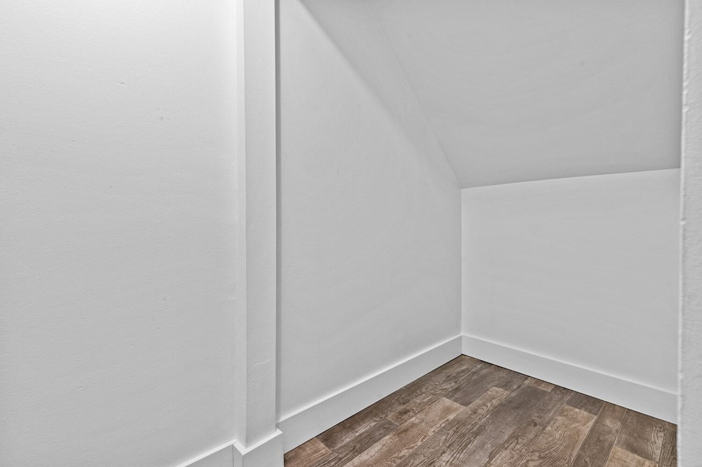 a small room with white walls and a wooden floor