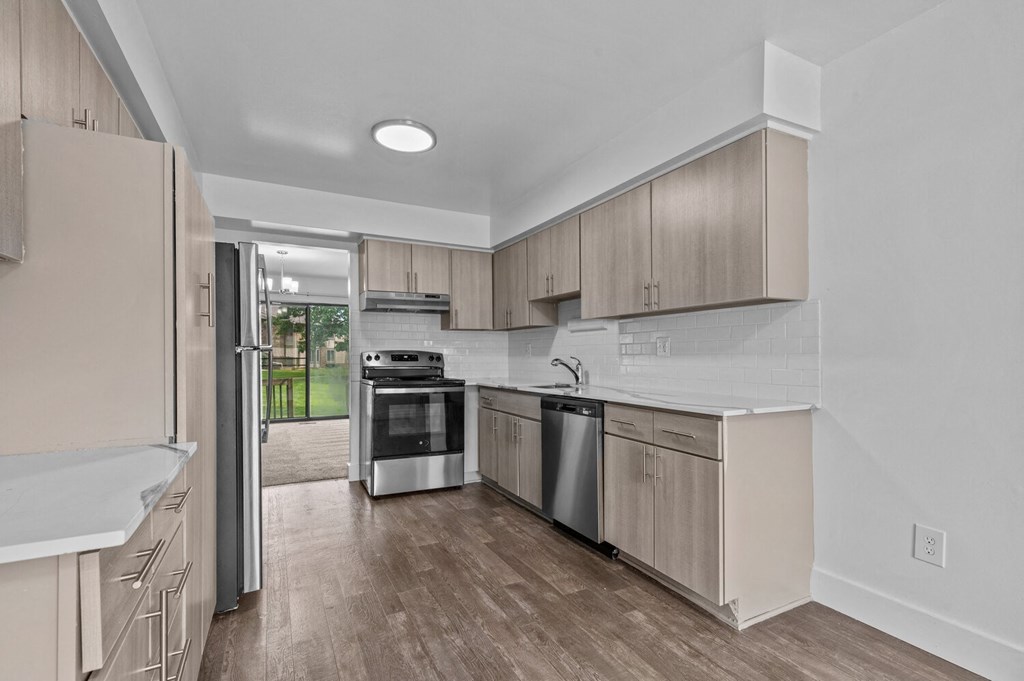 a kitchen with wooden cabinets and stainless steel appliances at Edge At Farmington Hills - Farmington Hills, MI, Michigan