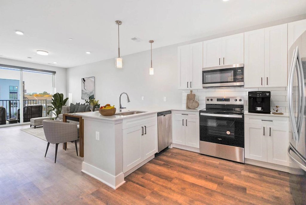 A modern kitchen with white cabinets and stainless steel appliances.