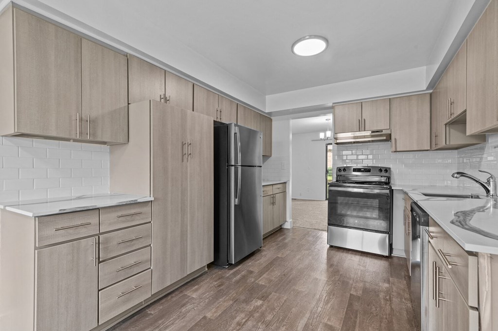 a kitchen with wooden cabinets and stainless steel appliances at Edge At Farmington Hills - Farmington Hills, MI, Michigan, 48334