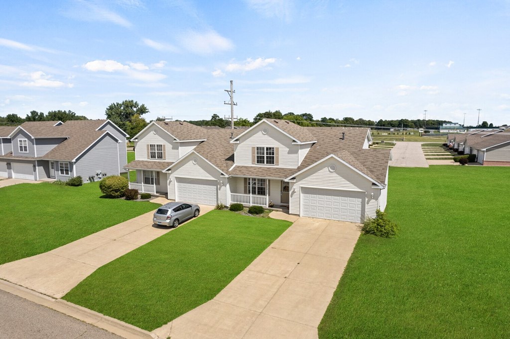 a row of houses in a neighborhood with a car parked in the driveway