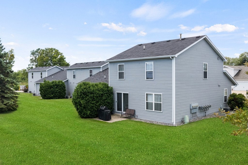 a gray house with a yard in front of it