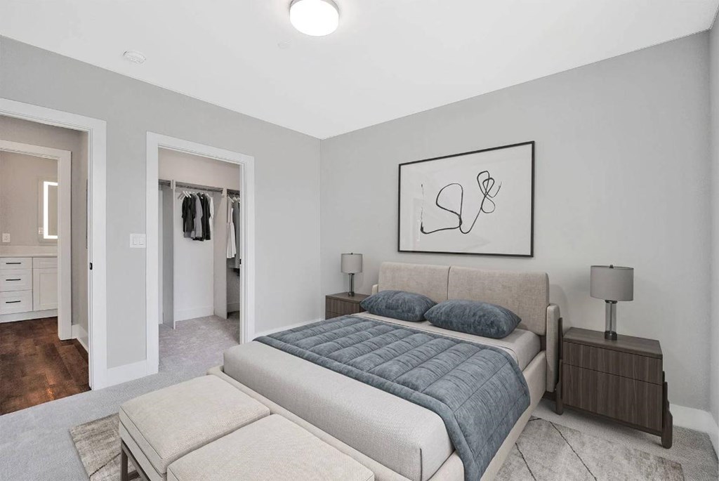 A bedroom with a bed, nightstand, and a painting on the wall.