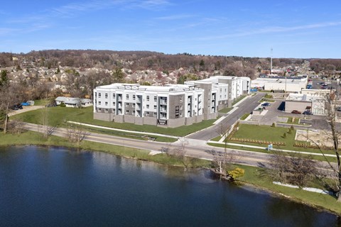 A large white building sits next to a body of water.