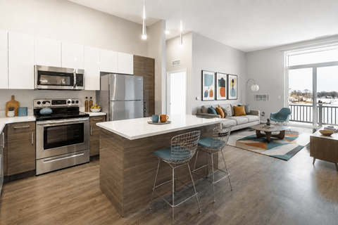A modern kitchen with a large island and a view of the outdoors.