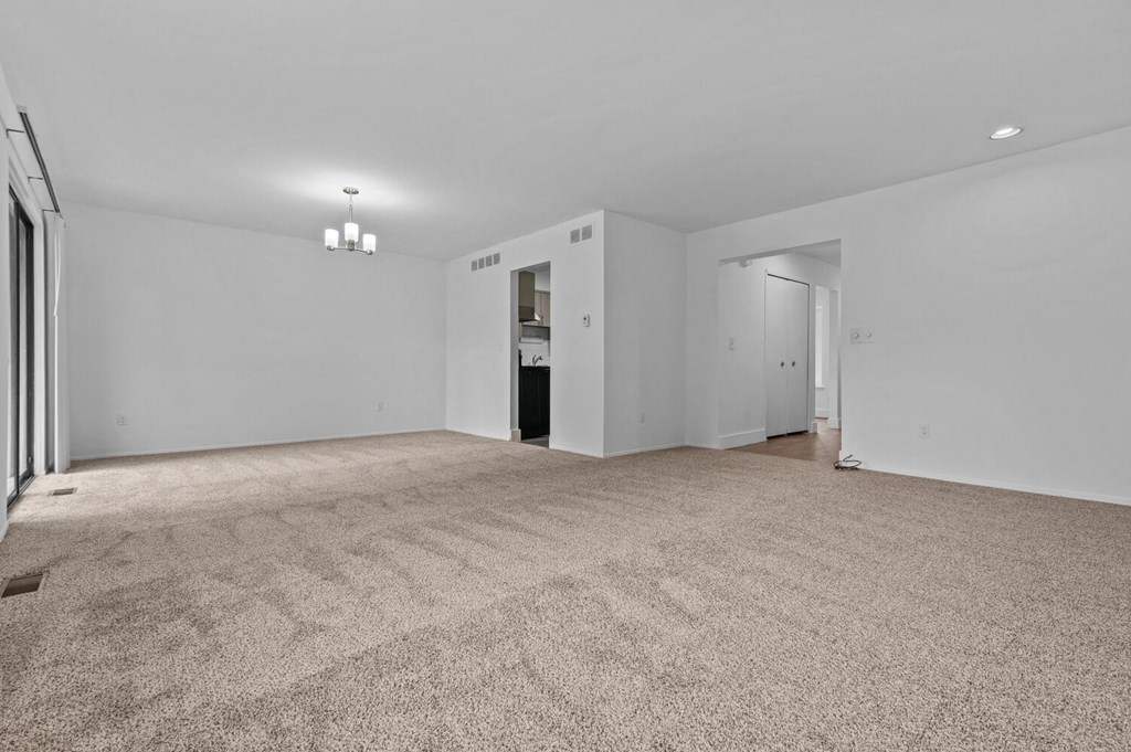 an empty living room with white walls and carpet at Edge At Farmington Hills - Farmington Hills, MI, Farmington Hills