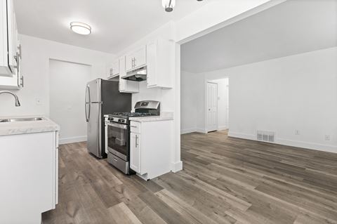 a renovated kitchen with white cabinets and a stainless steel stove and refrigerator