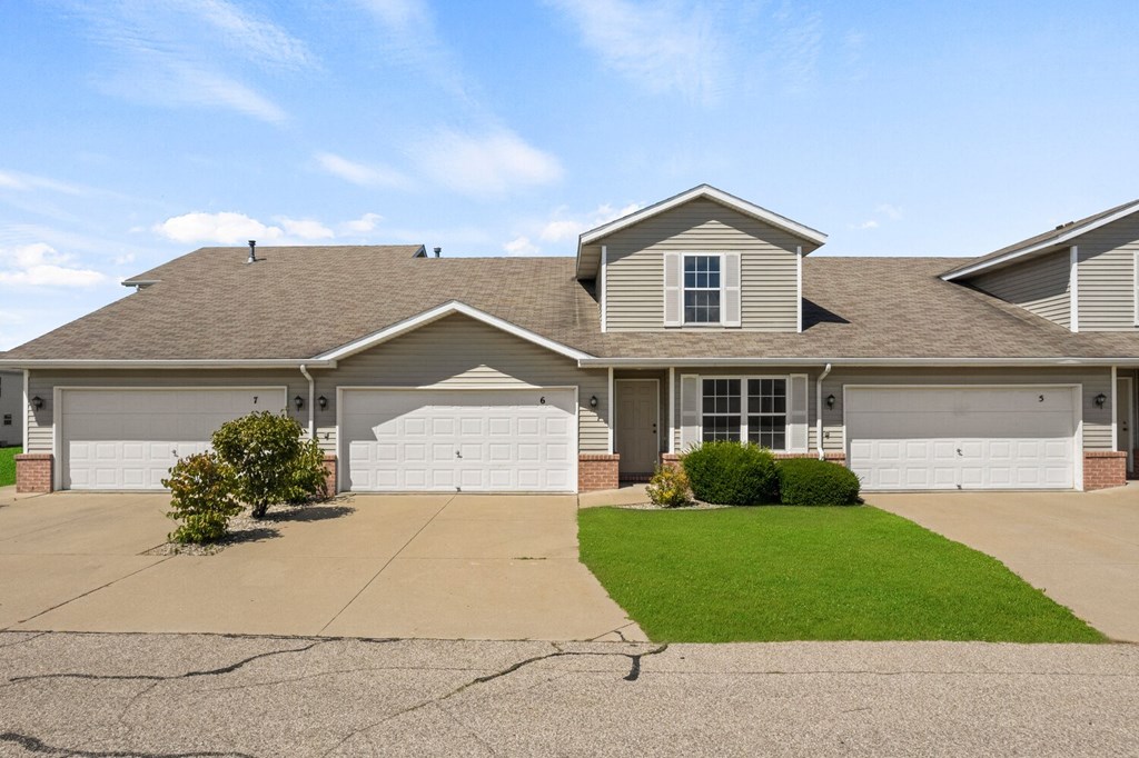 a house with two garage doors and a lawn