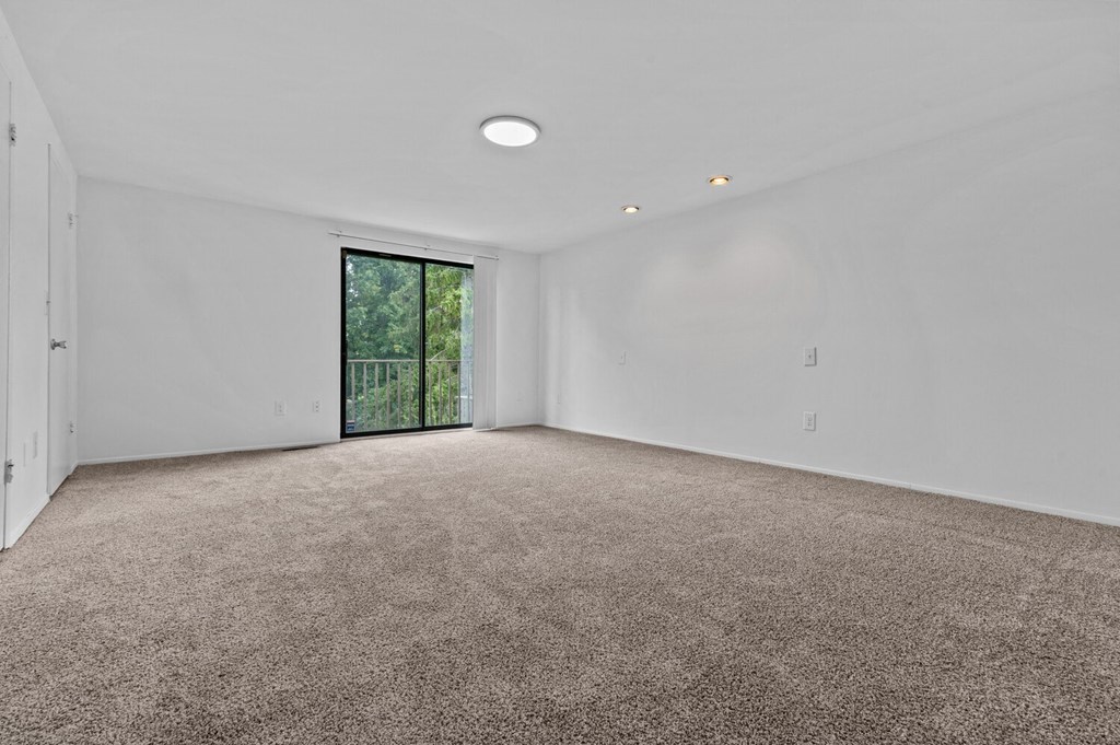 a living room with carpet and a door to a balcony at Edge At Farmington Hills - Farmington Hills, MI, Farmington Hills, 48334