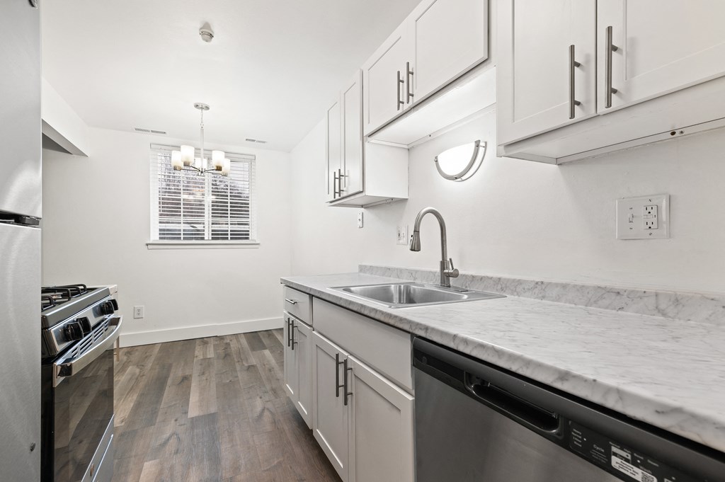 a renovated kitchen with marble counter tops and stainless steel appliances