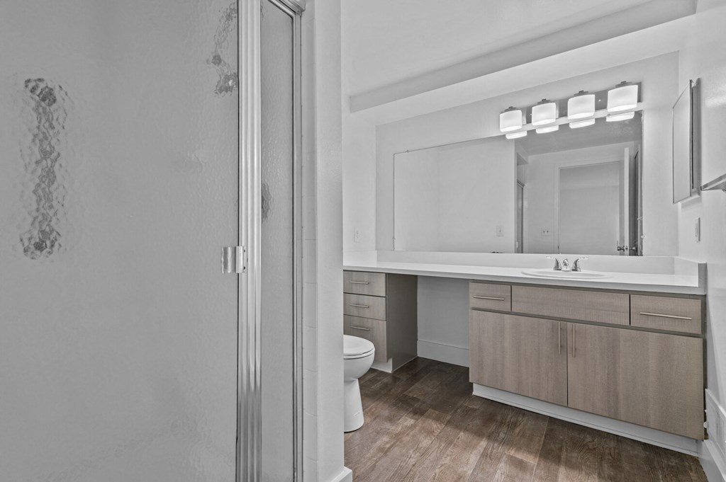 a bathroom with a toilet and a sink and a mirror at Edge At Farmington Hills - Farmington Hills, MI, Michigan