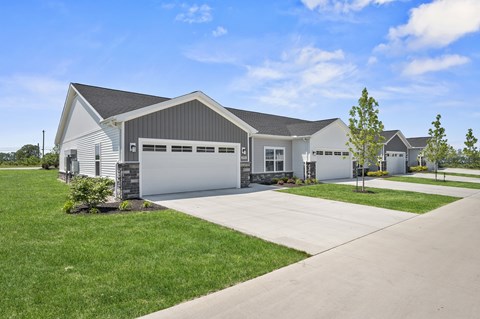 A large white building with a garage door is surrounded by a well-manicured lawn.