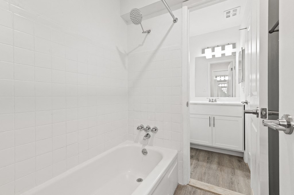 a white bathroom with a tub and a shower