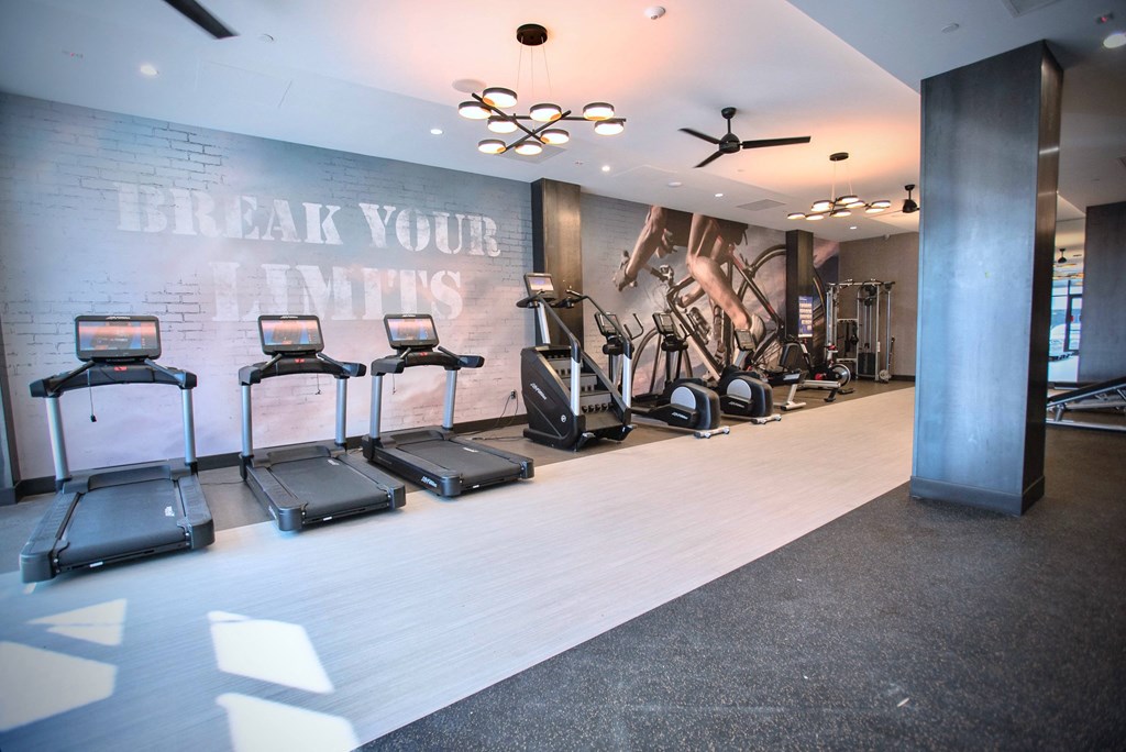 a fitness room with treadmills and other exercise equipment