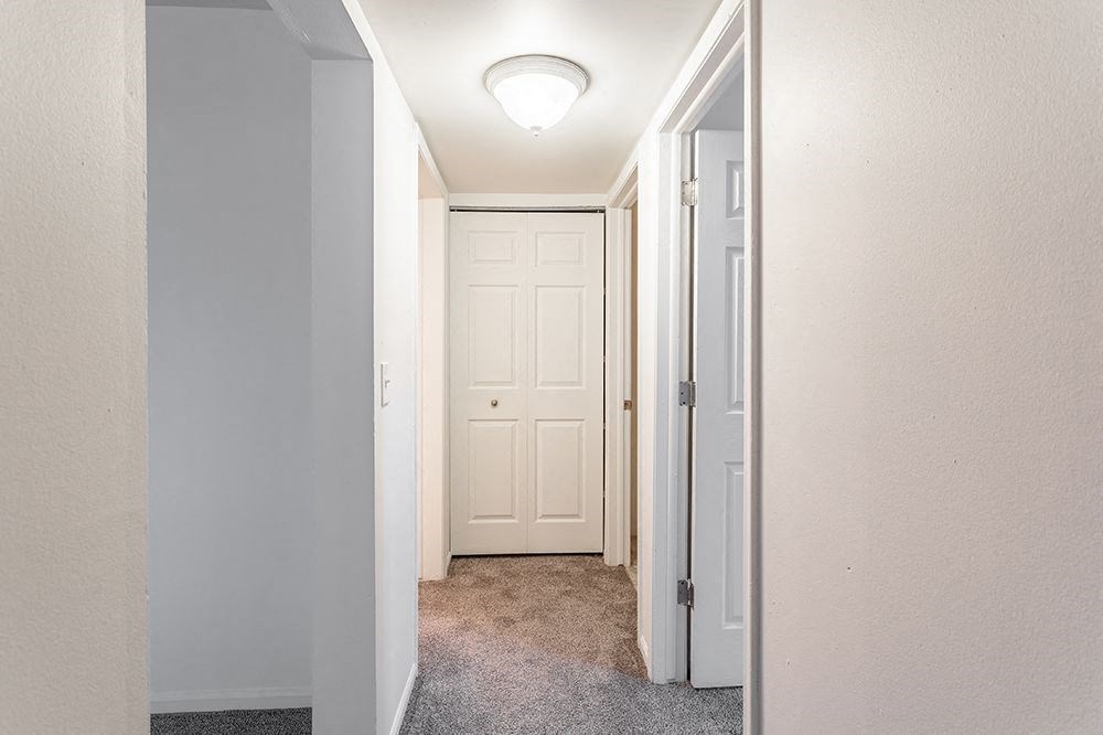 a hallway with a closet and a door to a bedroom