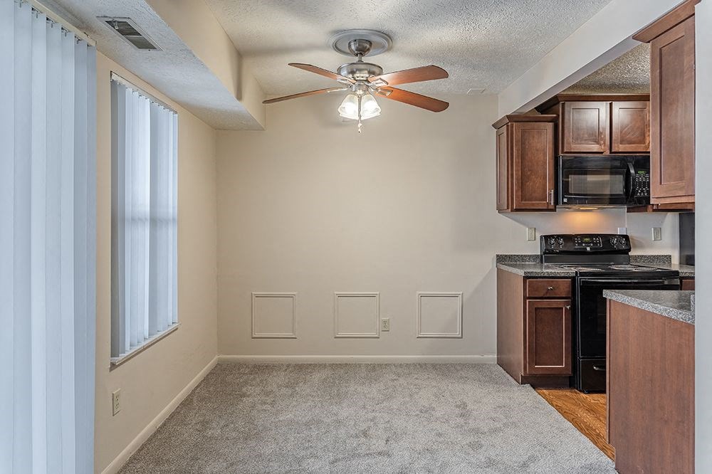 a kitchen with a ceiling fan and a window