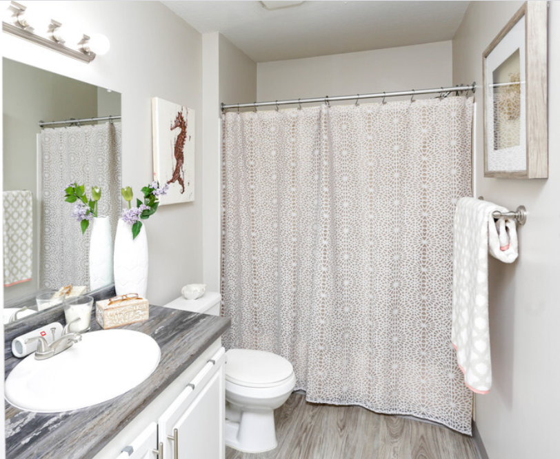 a bathroom with a white sink and toilet and a white shower curtain