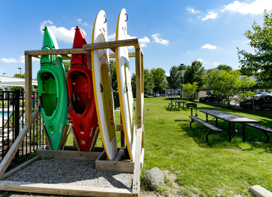 a group of kayaks on a rack in a park