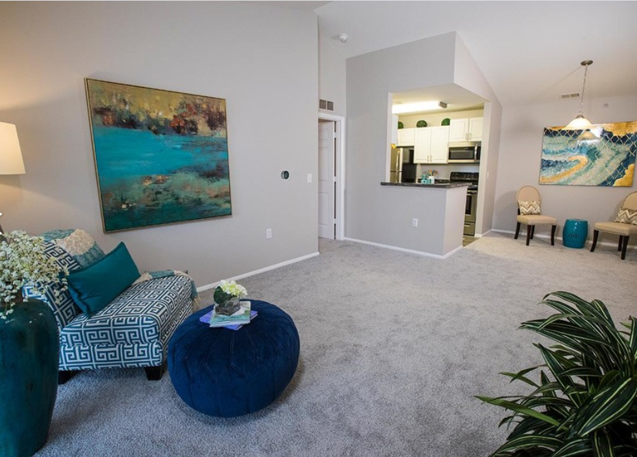 a living room with a couch and a chair and a kitchen