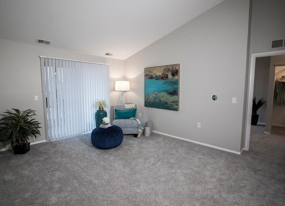 a living room with a couch and a chair and a painting on the wall