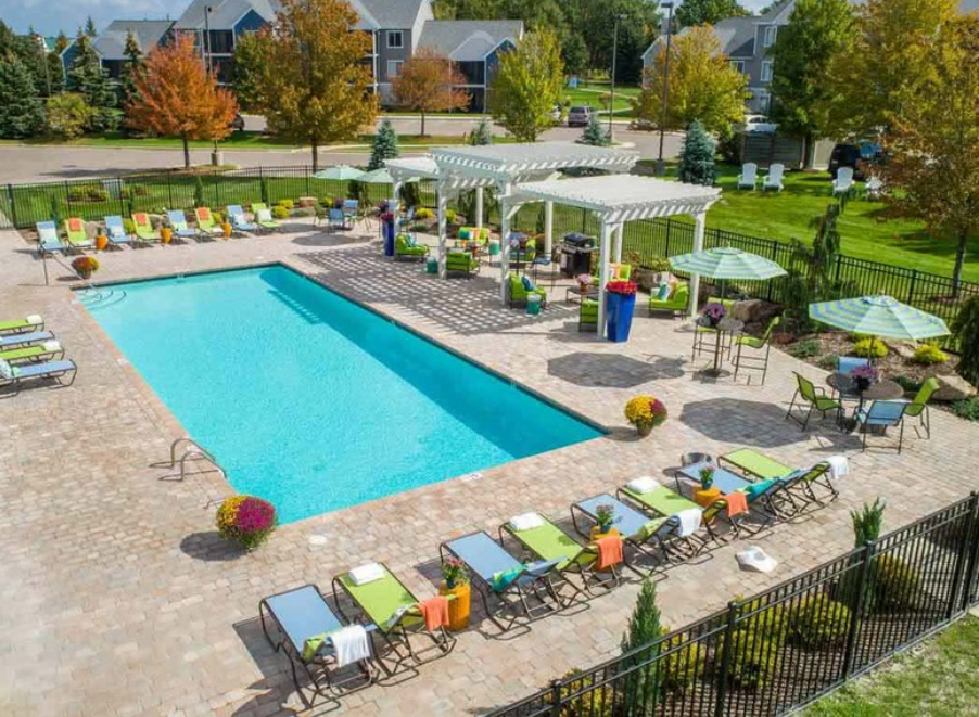 an aerial view of a swimming pool with chairs and umbrellas