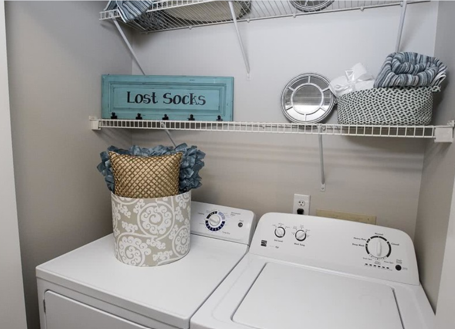 a white washer and dryer in a laundry room with a shelf above it