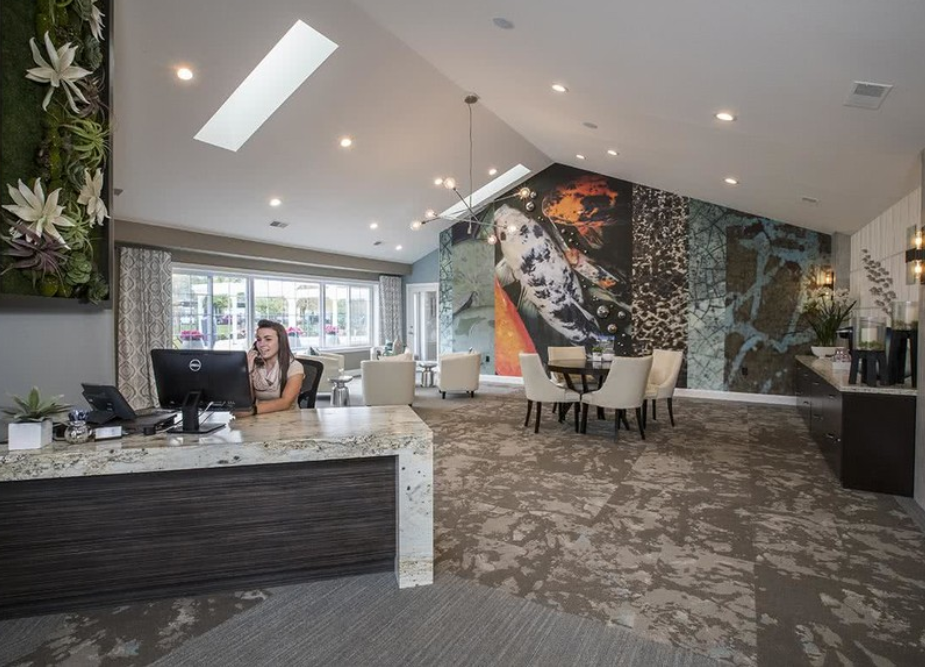 a woman sitting at a desk in a lobby with a computer