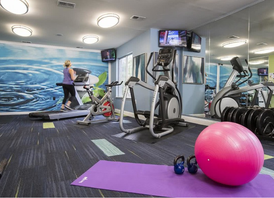 a gym with exercise equipment and a yoga ball on the floor