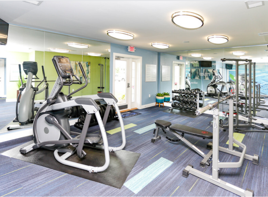 a gym with cardio equipment and weights in a building