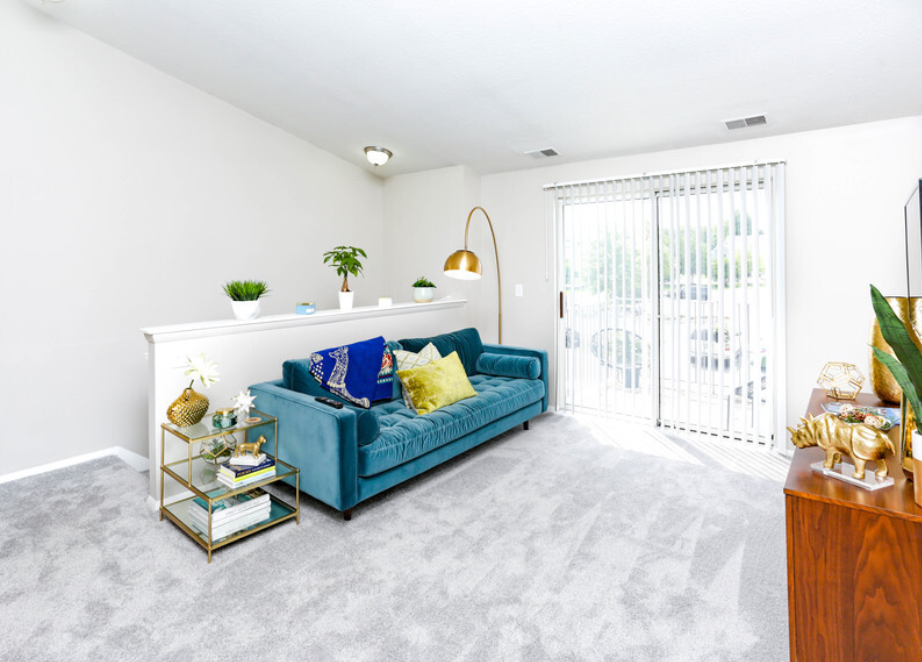 a living room with a blue couch and a patio door