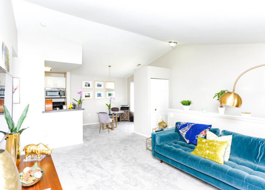 a living room with a blue couch and a kitchen