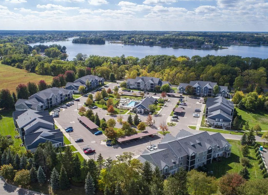 an aerial view of an apartment complex with a lake in the background