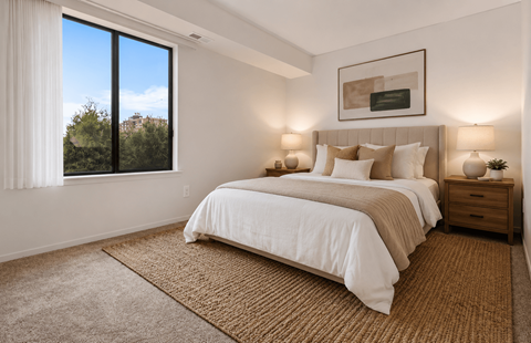 A bedroom with a large bed and a window overlooking trees. at Park On Canal Apartments - Clinton Twp, MI Apartments, Michigan, 48038