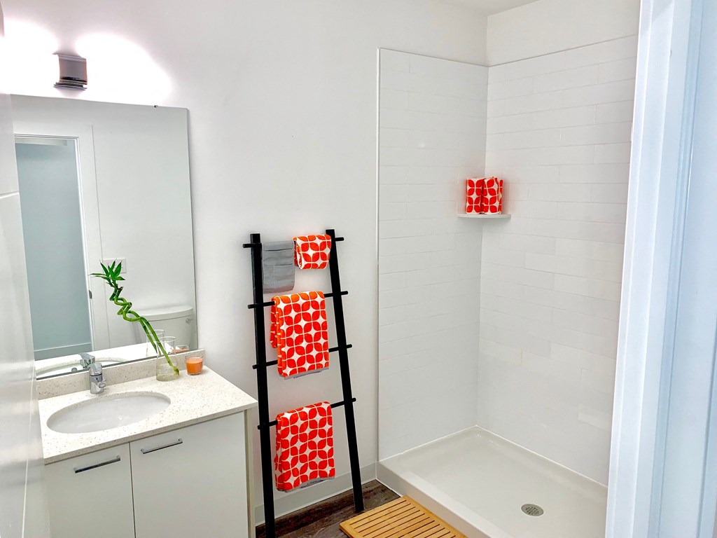 a small bathroom with a shower and a sink and a ladder