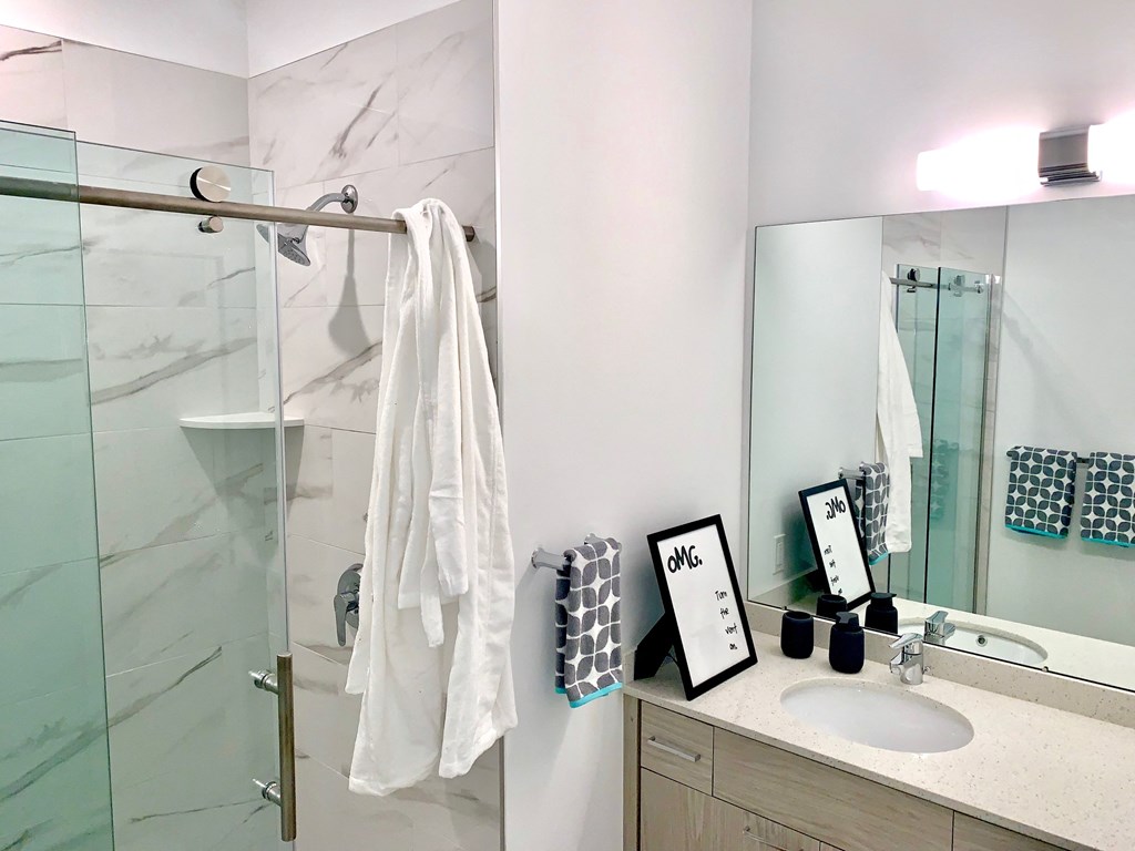 a bathroom with a shower and a sink and a mirror