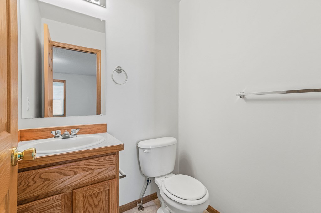 a bathroom with a toilet and a sink and a mirror