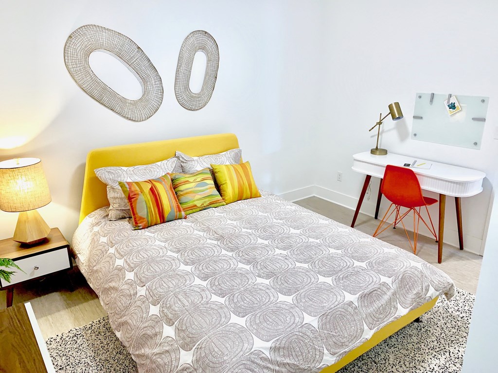 a bedroom with a bed and two mirrors on the wall