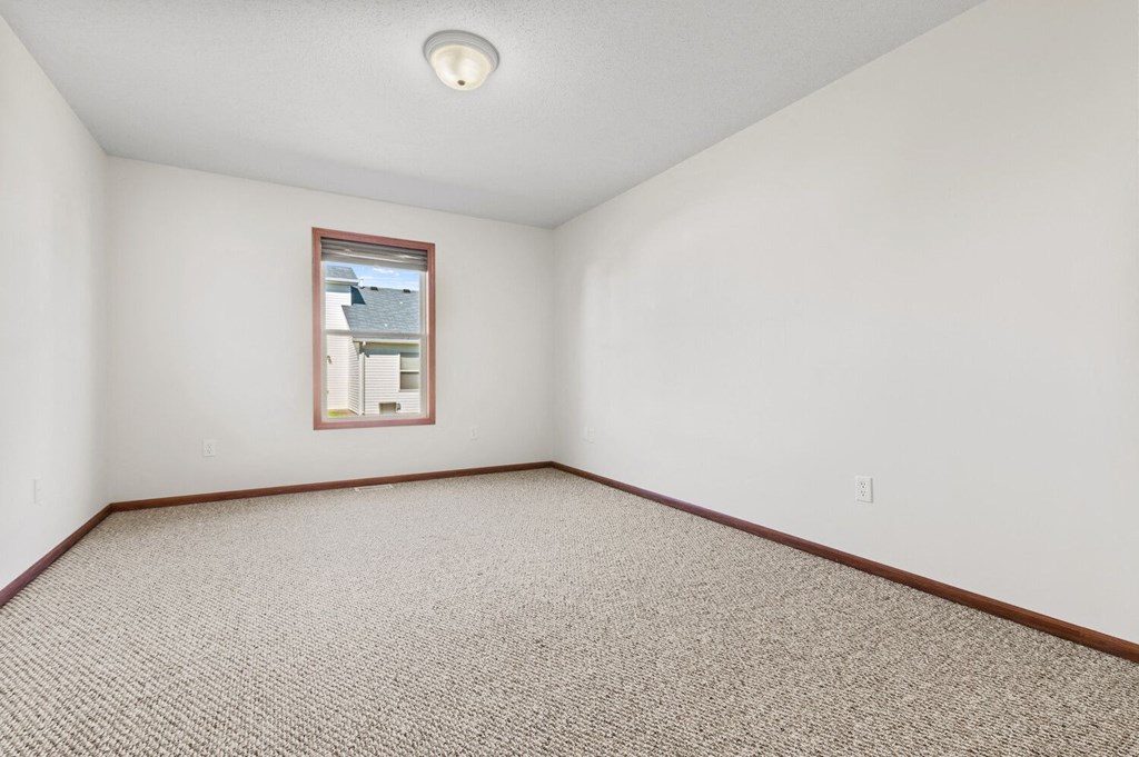 an empty room with carpet and a window