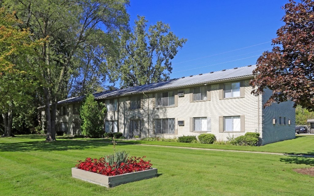 a large white house with a garden in front of it