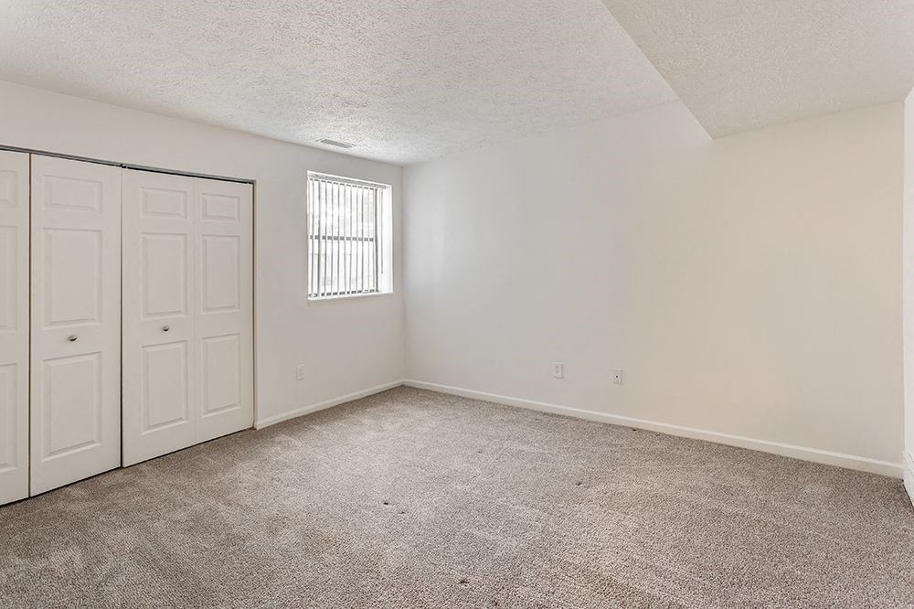 an empty living room with a closet and a door