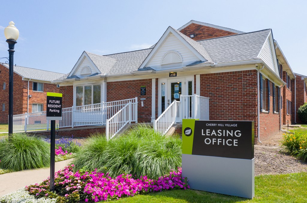 a leasing office sign in front of a brick building