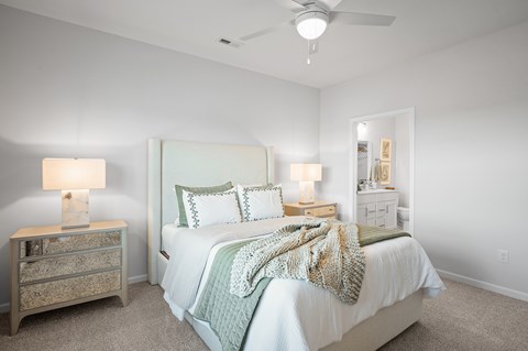 A bedroom with a bed, nightstand, and lamp.