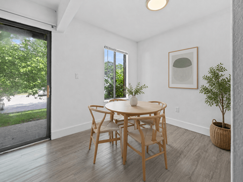 A dining room with a table and chairs.