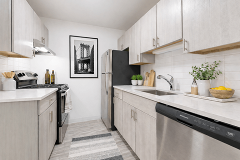 A kitchen with white cabinets and a black fridge.