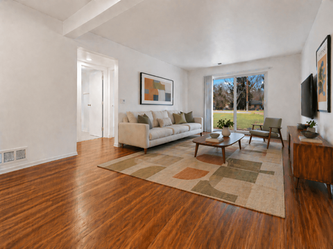 A living room with a white couch and a rug.
