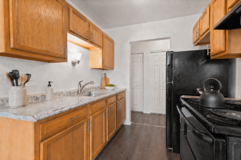 A kitchen with wooden cabinets and a black stove.